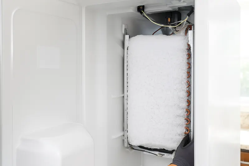 Freezer evaporator coil completely encased in thick white frost after a defrost system failure